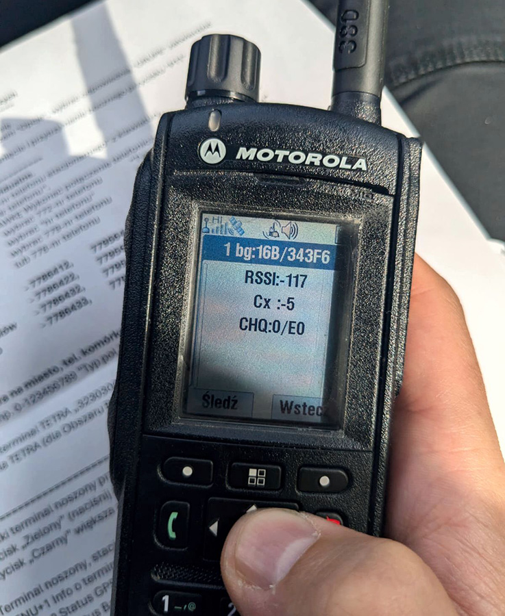 pracownik TAURON Dystrybucja trzyma w ręku aparat telefoniczny cyfrowego systemu łączności radiowej Tetra