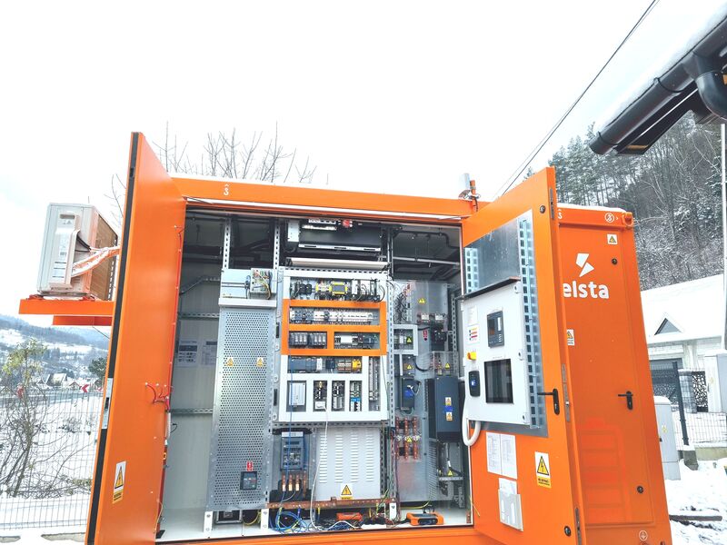 grupa czterech mężczyzn stoi przed wnętrzem otwartej budowli magazynu energii