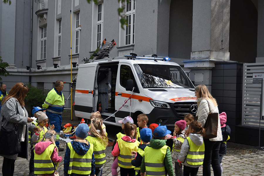 grupa przedszkolaków obserwuje odsłonięcie figurki krasnala Voltusia