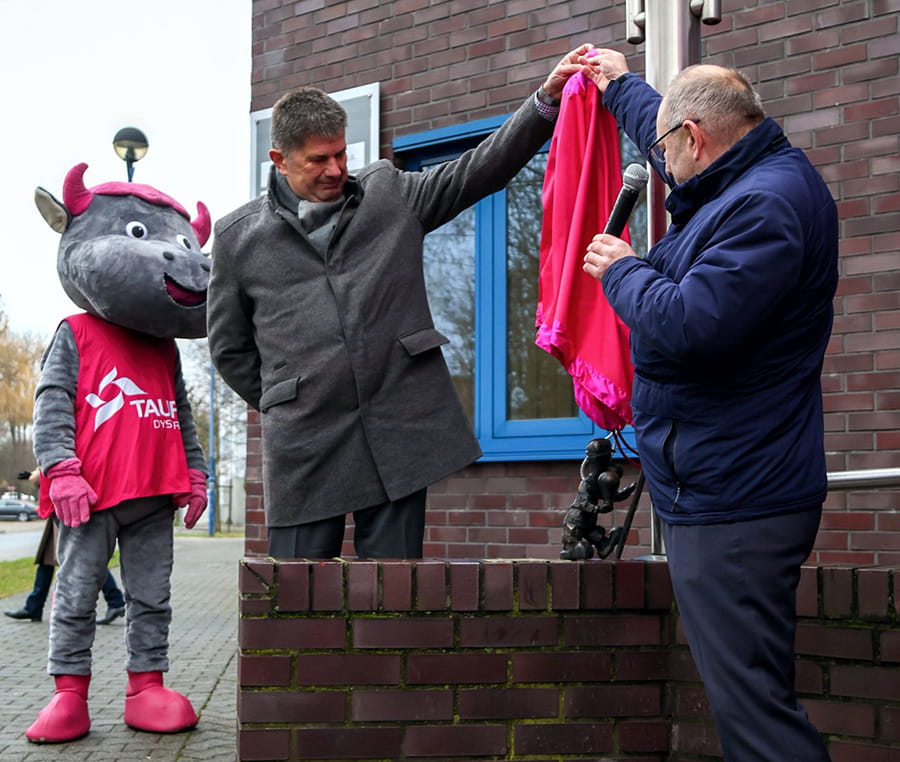 dwóch panów odsłania figurę Beboka Sztromka przed budynkiem rejonu energetycznego w Katowicach