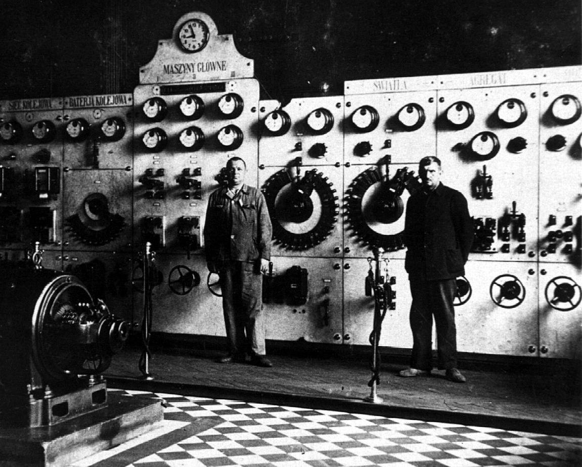 na czarnobiałym zdjęciu wykonanym w 1927 roku w Tarnowie dwóch energetyków stoi na tle sterowni głównej elektrowni