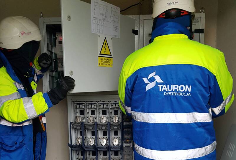 dwóch pracowników Tauron Dystrybucja sprawdza skrzynkę elektryczną