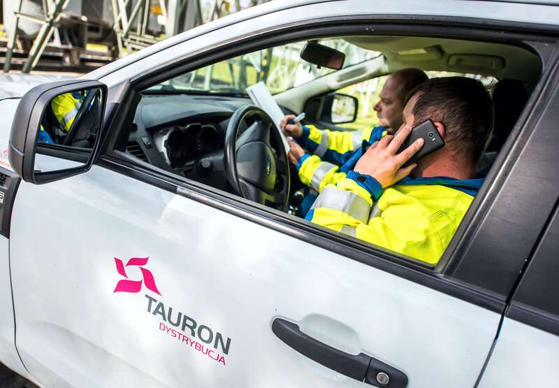 pracownik Tauron Dystrybucji rozmawia przez telefon w samochodzie pogotowia energetycznego
