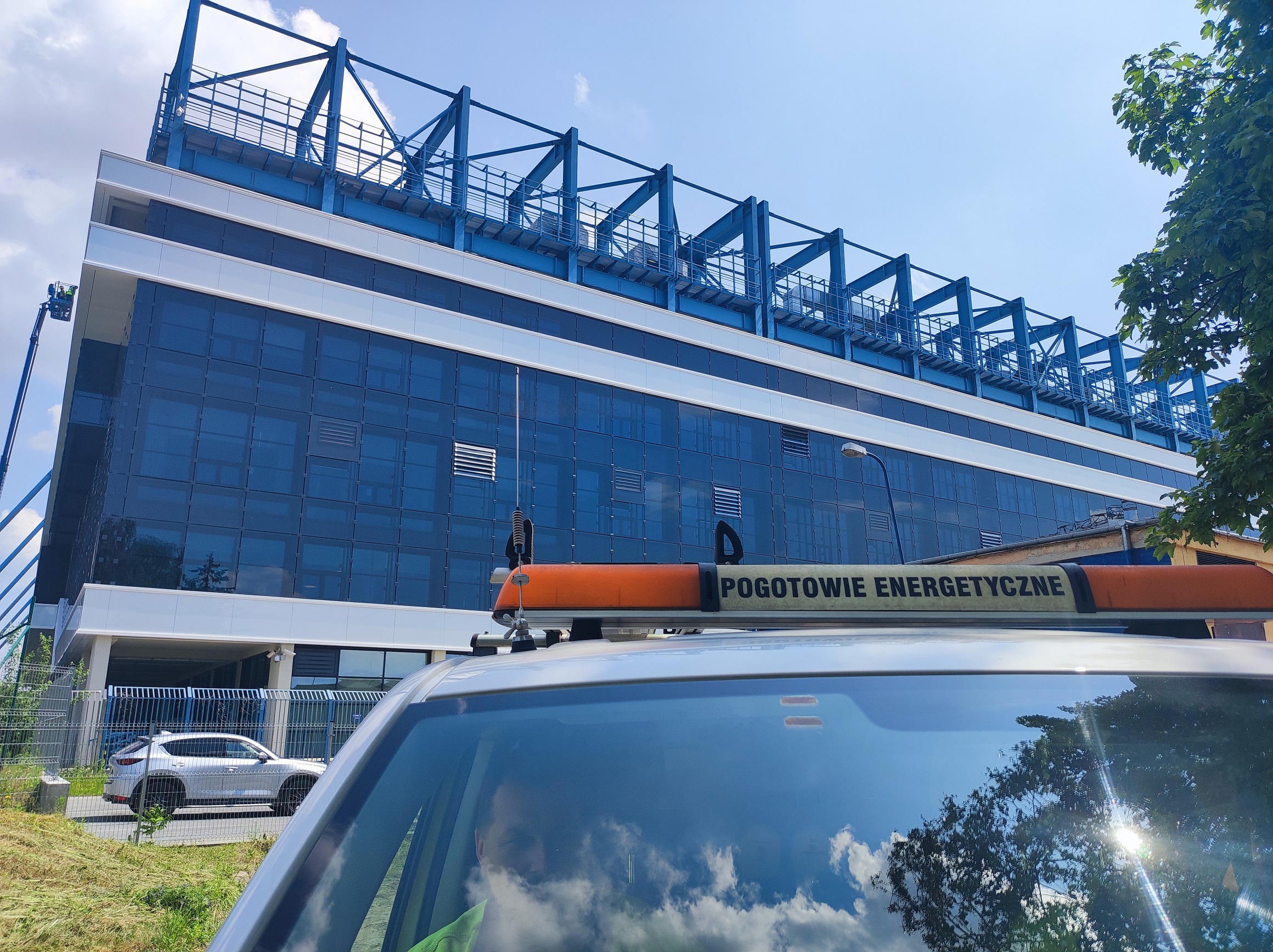 samochód pogotowia energetycznego stoi przy hali sportowej