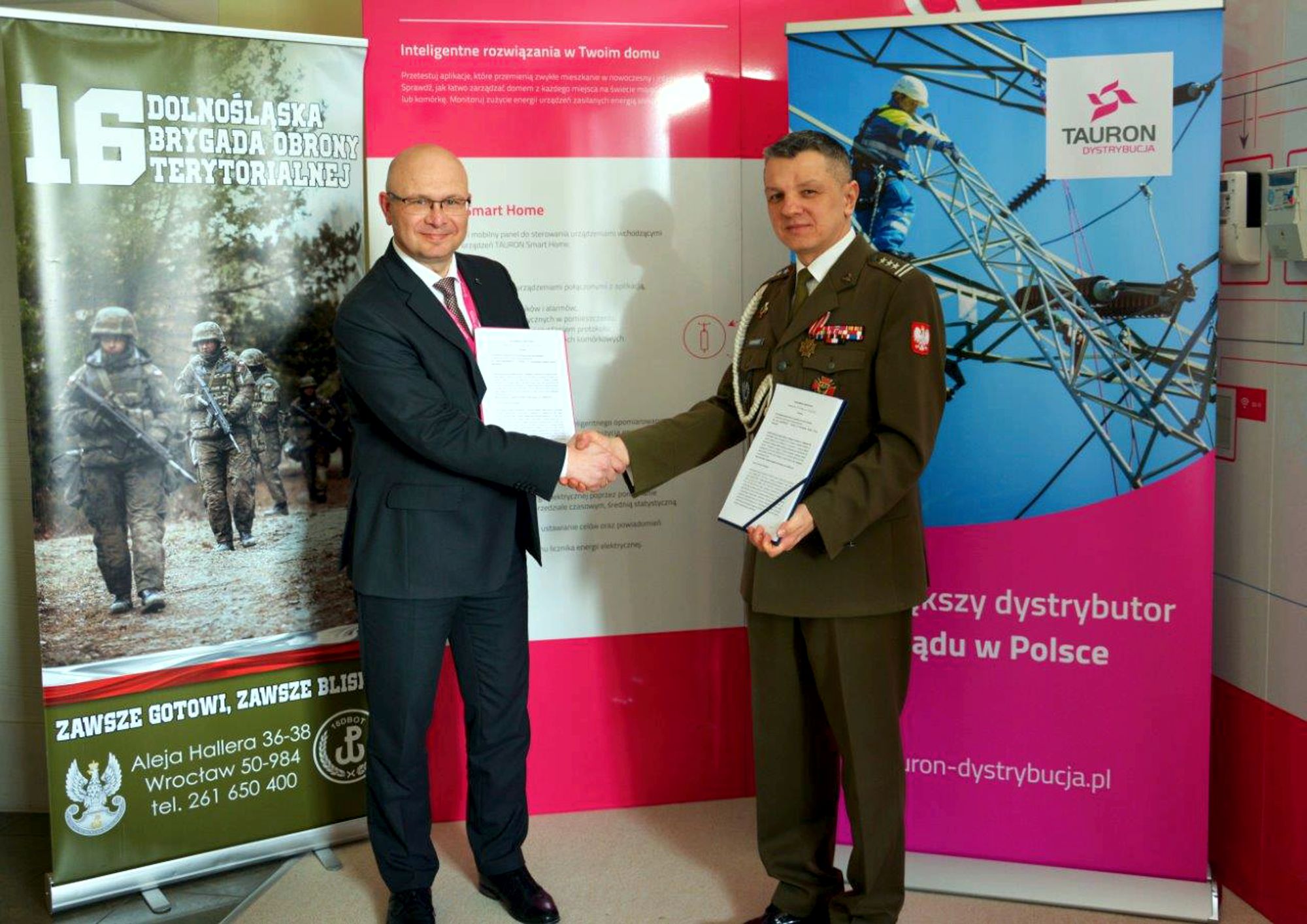 przedstawiciele Tauron Dystrybucji i Wojsk Obrony Terytorialnej ściskają sobie dłonie po podpisaniu porozumienia o współpracy