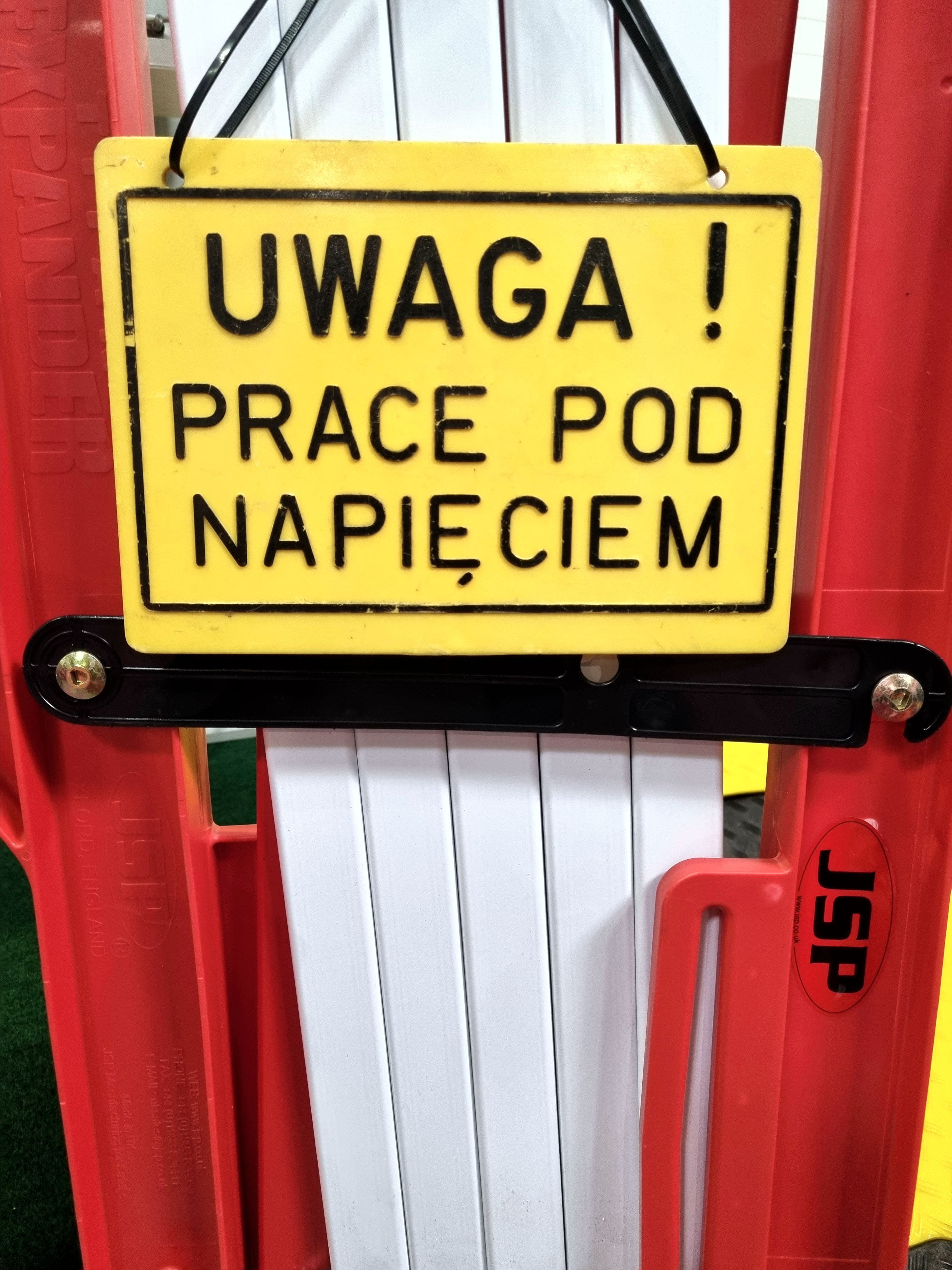 żółta tabliczka z napisem Uwaga, Prace pod napięciem