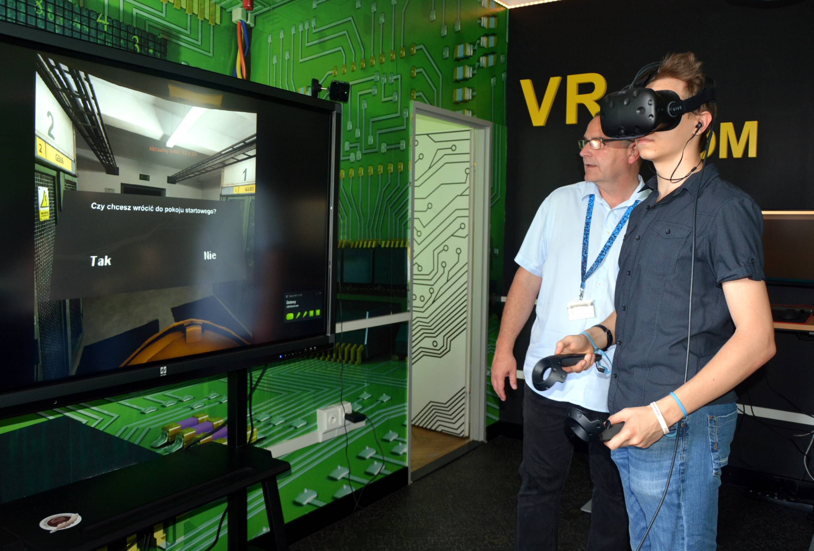 uczeń z założonymi goglami VR znajduje się w wirtualnej stacji energetycznej widocznej na monitorze