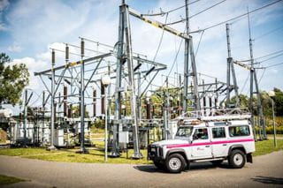 samochód pogotowia energetycznego stoi na tle instalacji stacji elektroenergetycznej
