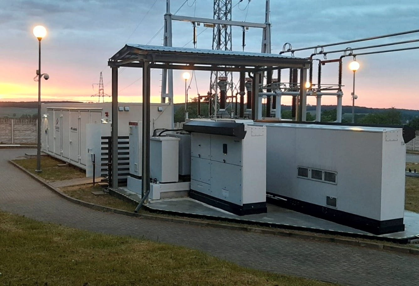 Nocny widok na oświetlony budynek magazynu energii elektrycznej znajdujący się w stacji energetycznej